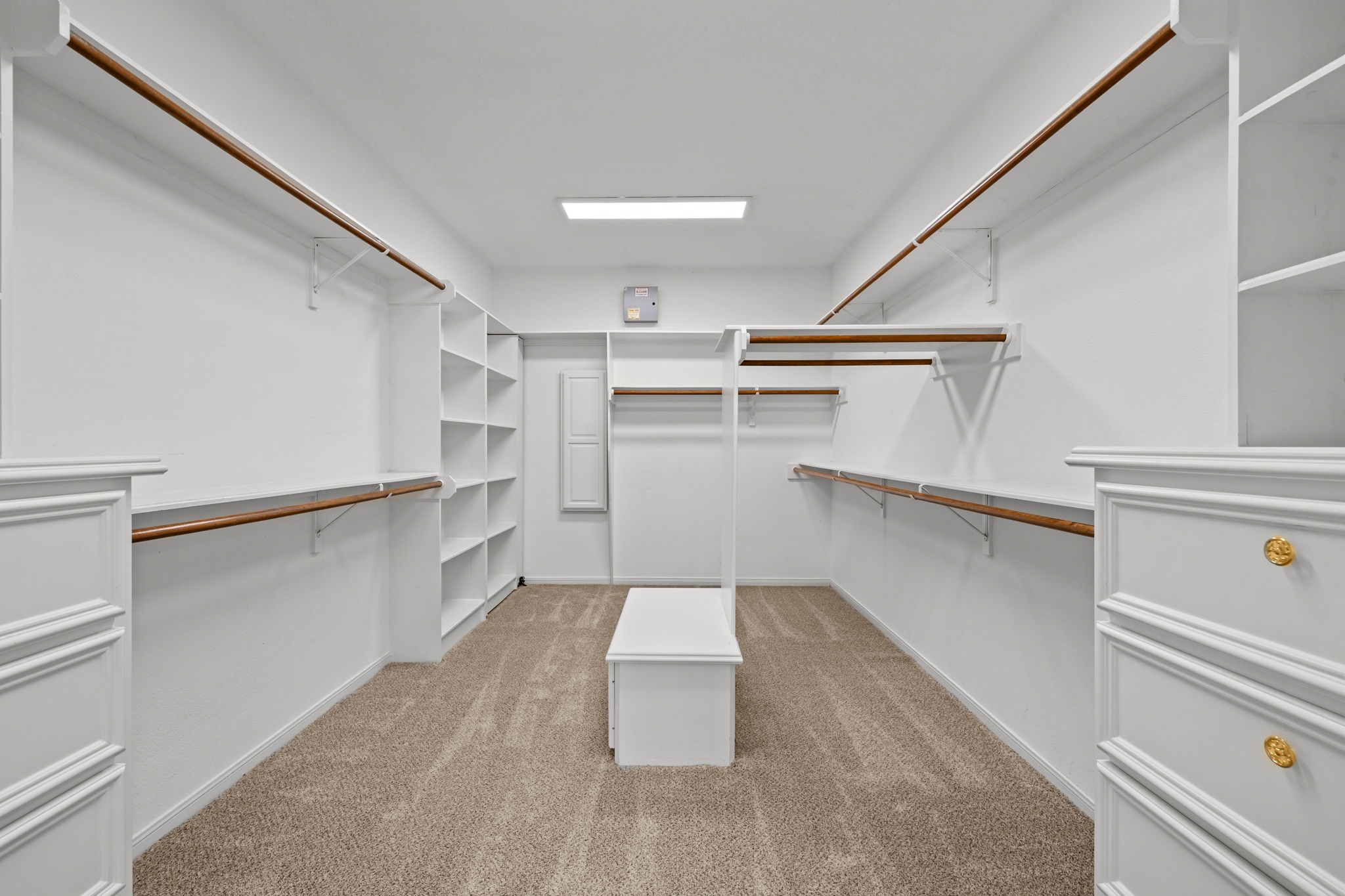 6410 Old Chocolate Bayou Road Manvel, TX 77578 - Photo 20 of 49 This spacious walk-in closet
features ample shelving and
hanging space, carpeted
flooring, and bright overhead
lighting, offering both
functionality and style for
organized storage.