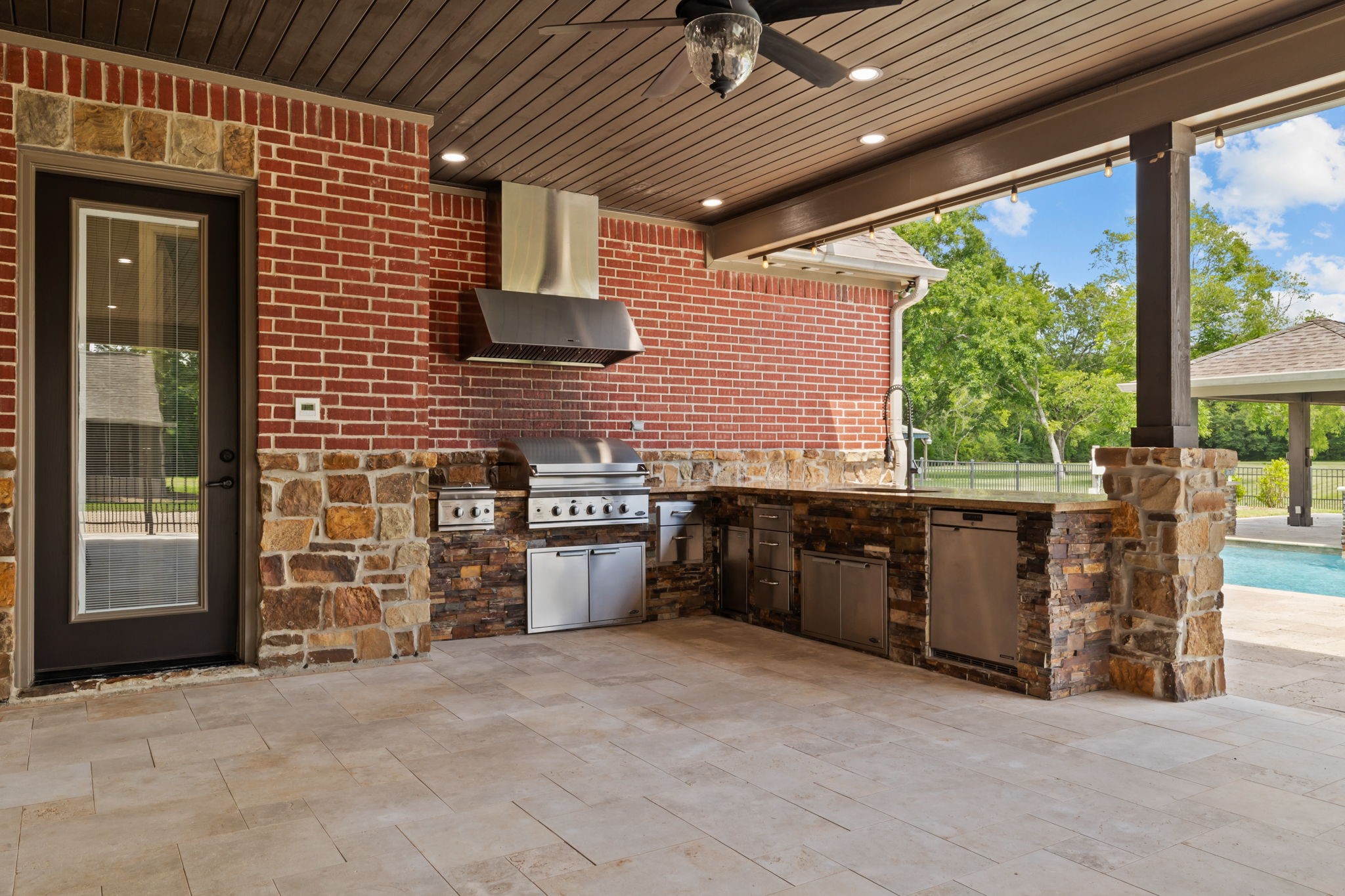 6410 Old Chocolate Bayou Road Manvel, TX 77578 - Photo 45 of 49 Luxurious outdoor kitchen
featuring a top-of-the-line grill,
ample counter space, and a
stunning stone finish, perfect for
entertaining by the pool.