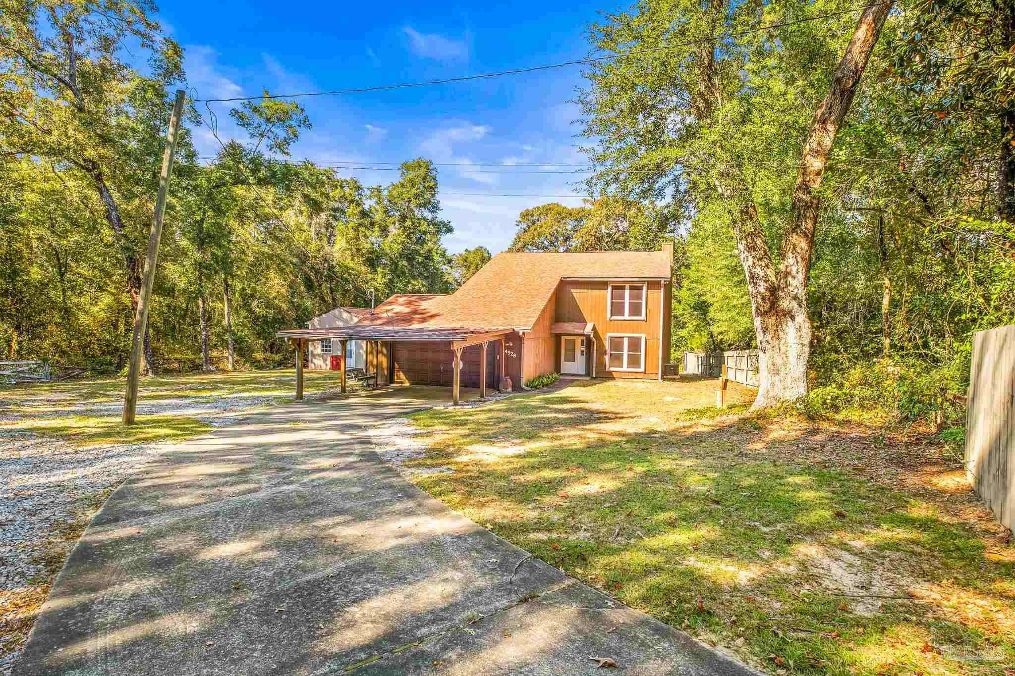 4928 Shell Road Milton, FL 32583 - Photo 3 of 60 a view of a house with a big yard and large trees