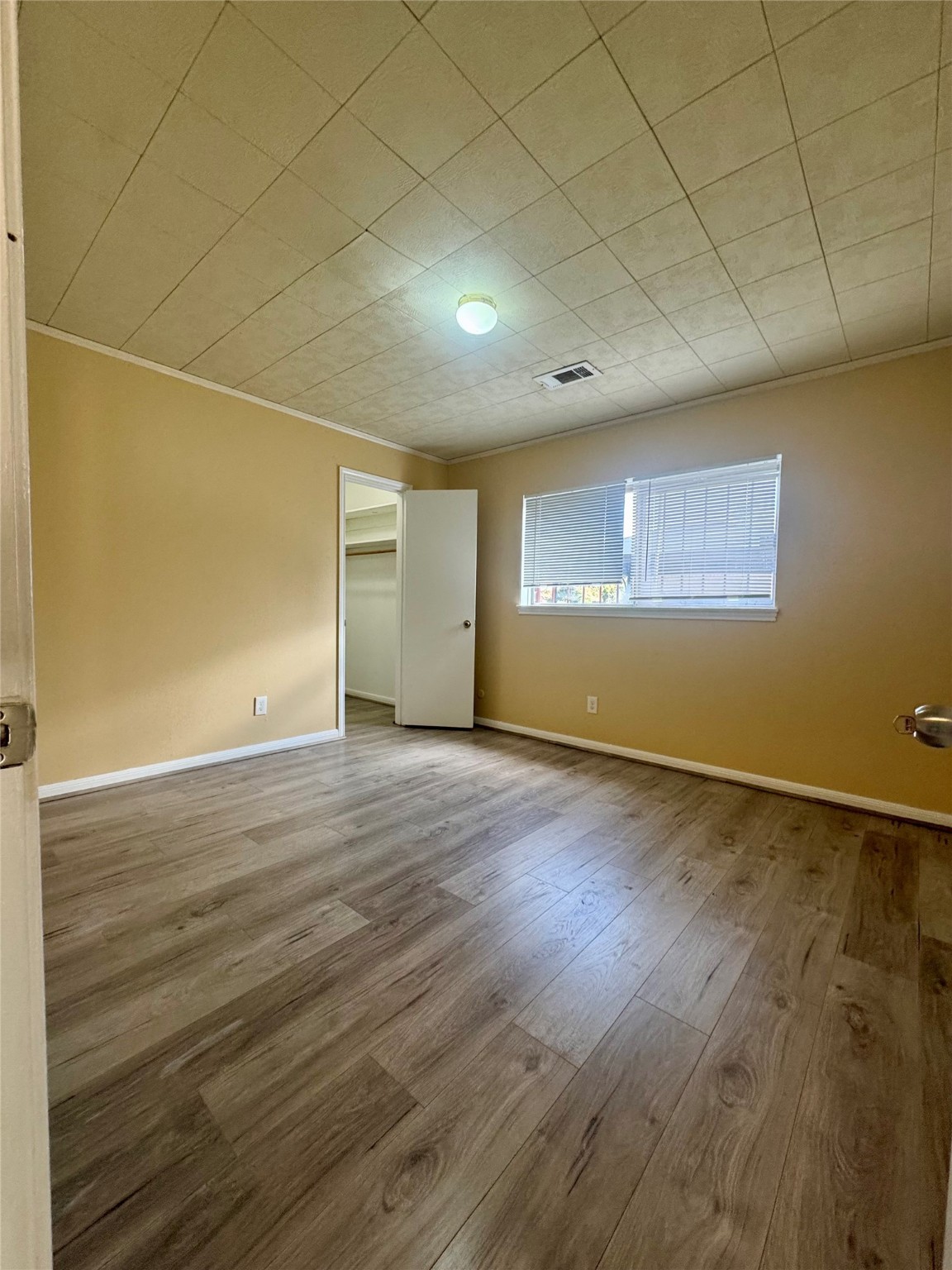 8418 Hazen Street Houston, TX 77036 - Photo 12 of 25 an empty room with wooden floor and windows