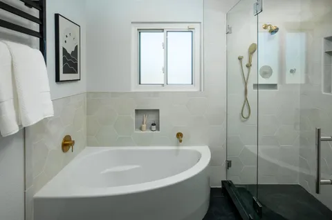 a white bath tub sitting next to a shower