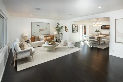 a living room with fireplace furniture and wooden floor