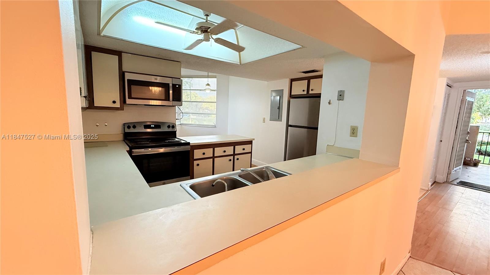 1811 Sabal Palm Drive, Unit 208 Davie, FL 33324 - Photo 9 of 32 a large kitchen with stainless steel appliances a stove a refrigerator white cabinets and wooden floor