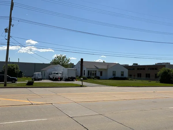 a view of a house with a big yard and potted plants