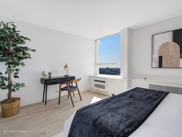 a bedroom with a bed and a potted plant
