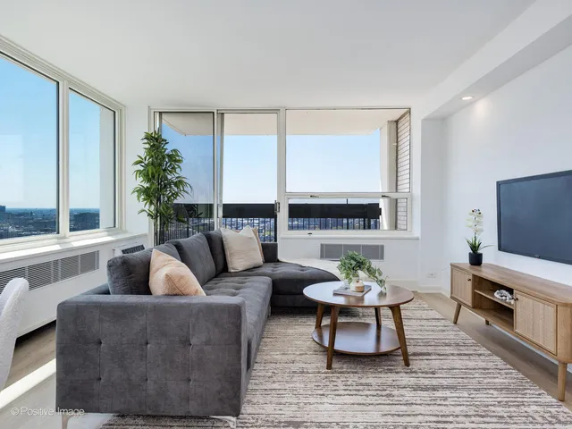 a living room with furniture a large window and a flat screen tv