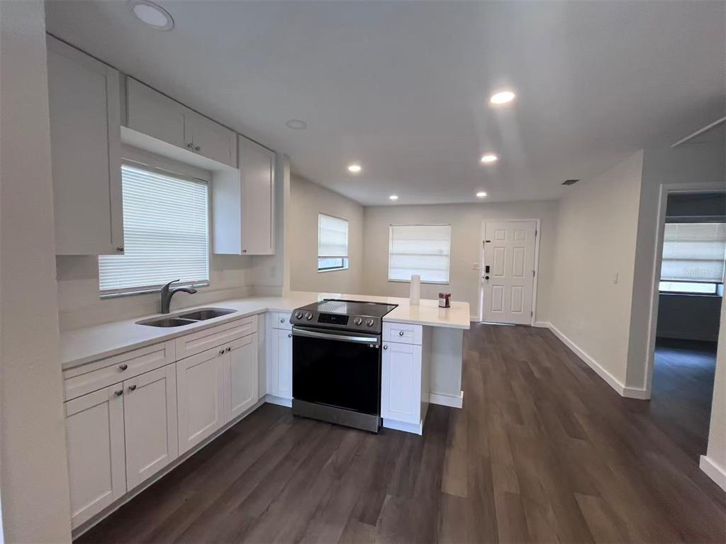 1016 9th Avenue Northwest, Unit B Largo, FL 33770 - Photo 4 of 11 a large kitchen with wooden floors and stainless steel appliances