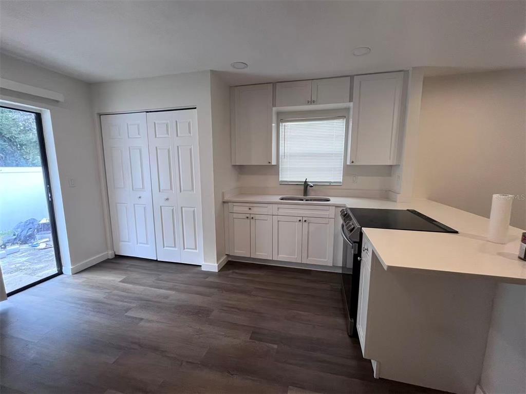 1016 9th Avenue Northwest, Unit B Largo, FL 33770 - Photo 10 of 11 a kitchen with a sink a stove cabinets and wooden floor