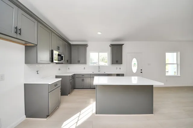 a large kitchen with kitchen island a sink stainless steel appliances and cabinets