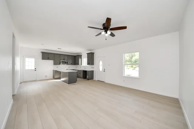 a view of a livingroom with a kitchen space with a sink dishwasher and a fireplace