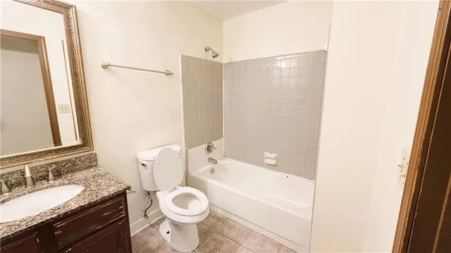 a bathroom with a granite countertop sink toilet a large mirror and shower
