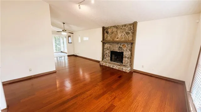 an empty room with wooden floor and a fireplace