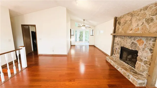 a view of a livingroom with wooden floor and a fireplace