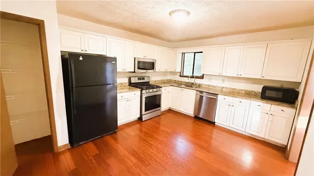 a kitchen with a refrigerator a sink dishwasher and a stove top oven