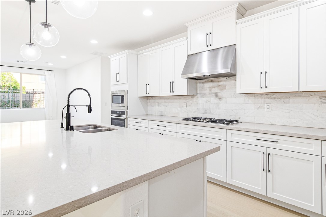 2182 Trivero Street Henderson, NV 89044 - Photo 15 of 50 Gleaming stone countertops and a spacious prep island anchor this refined kitchen workspace.