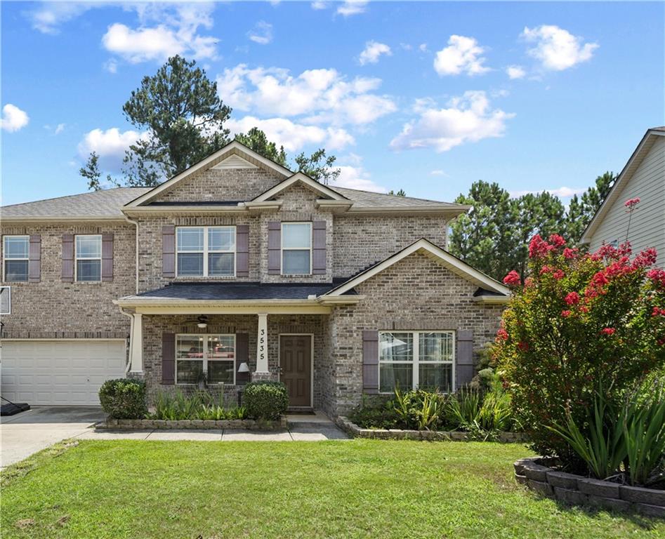 a front view of a house with a yard and potted plants