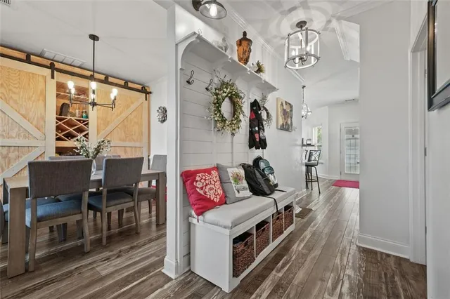 a living room with furniture a chandelier and wooden floor