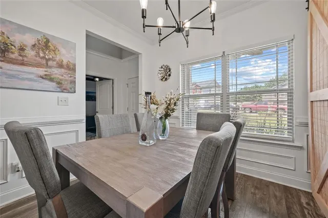 a view of a dining room with furniture a chandelier and wooden floor