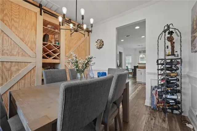 a living room with furniture a chandelier and wooden floor