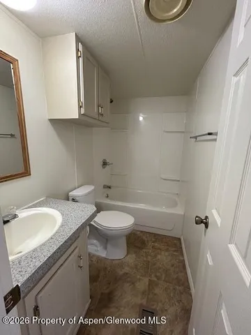 a bathroom with a granite countertop sink a toilet and a bathtub
