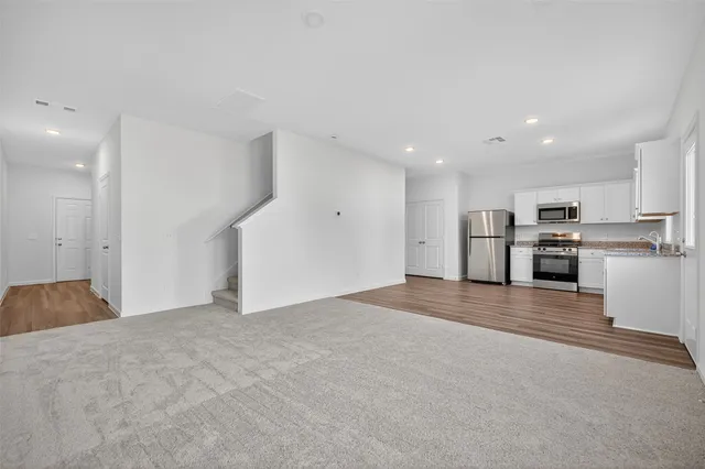 a view of a kitchen with a sink stove refrigerator and cabinets