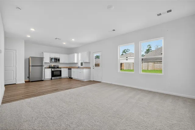 a view of a kitchen with a sink stove refrigerator and a window
