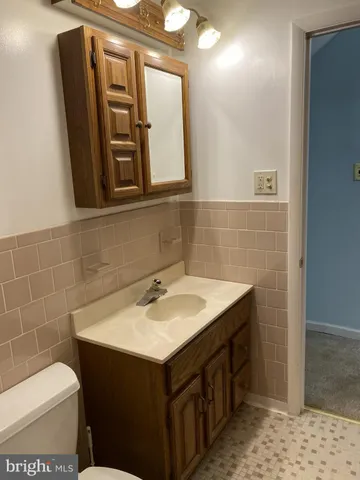a bathroom with a sink a toilet and mirror