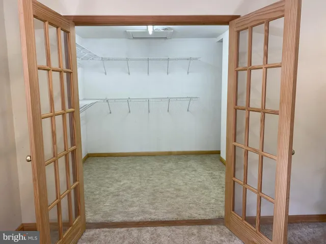 a view of a patio with couches table and chairs under an umbrella with trees