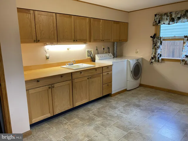 a kitchen with stainless steel appliances a sink window and cabinets