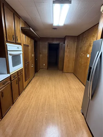 a view of a kitchen with wooden floor and electronic appliances