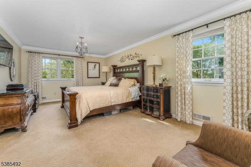 48 West Main Street Mendham, NJ 07945 - Photo 17 of 28 a bedroom with a large bed and a chandelier