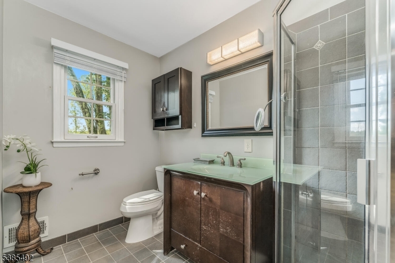 48 West Main Street Mendham, NJ 07945 - Photo 19 of 28 a bathroom with a toilet sink and mirror