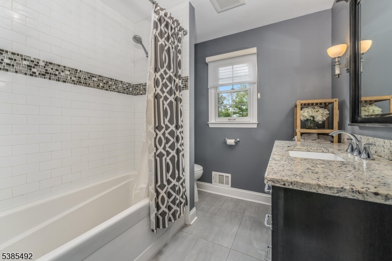 48 West Main Street Mendham, NJ 07945 - Photo 20 of 28 a bathroom with a granite countertop sink a toilet and bathtub