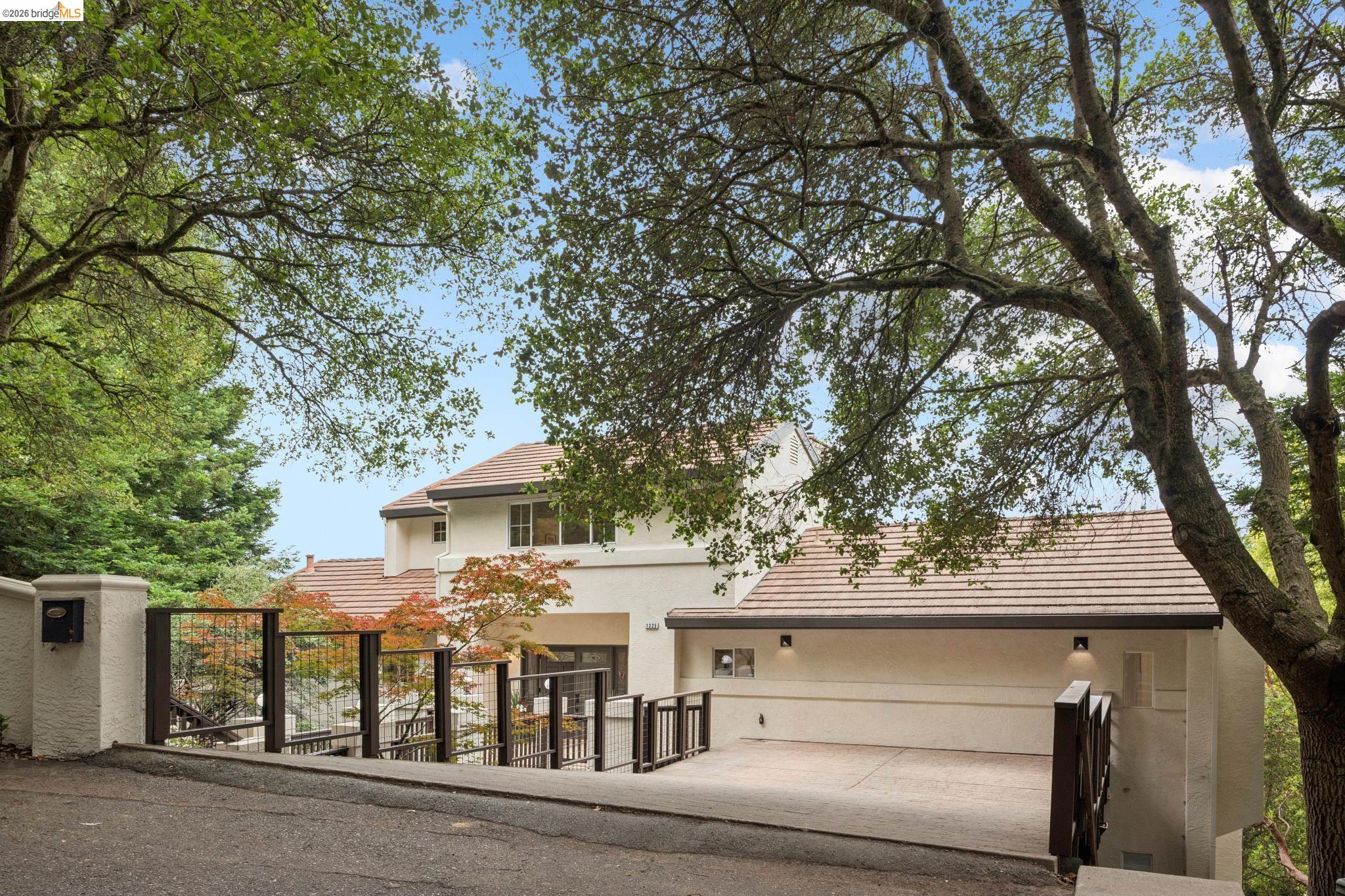 1325 Drury Road Berkeley, CA 94705 - Photo 6 of 71 Exterior residence featuring a terracotta-tiled roof, off-white stucco facade, and an integrated two-car carport