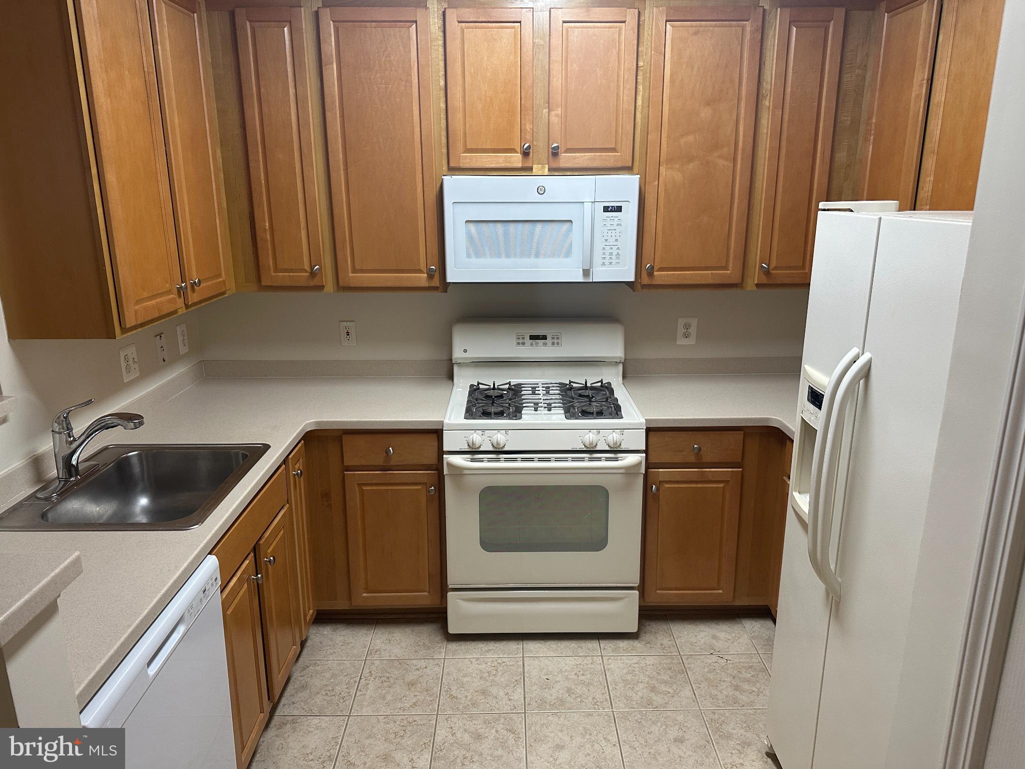 12001 Market Street, Unit 306 Reston, VA 20190 - Photo 9 of 13 Cozy kitchen with warm wooden cabinetry.