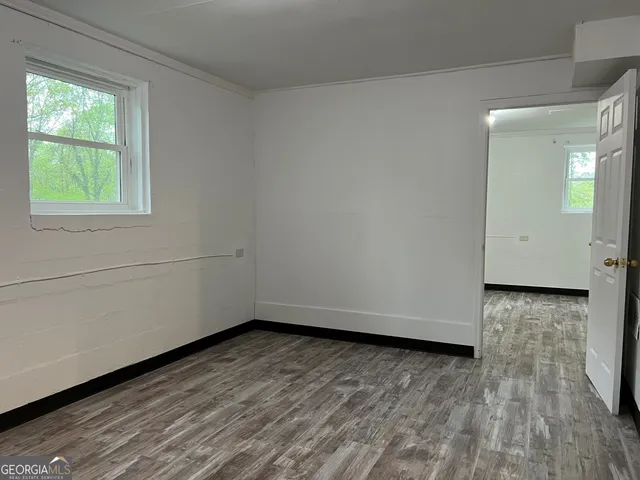 a view of a room with wooden floor and natural light