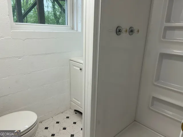 a bathroom with a toilet and a shower