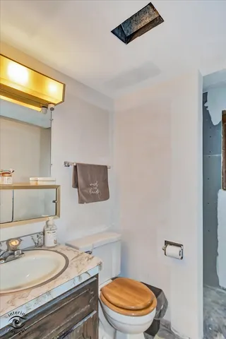 a bathroom with a granite countertop sink mirror vanity and toilet