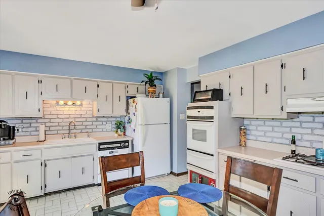 a kitchen with white cabinets and stainless steel appliances