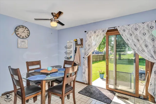 a view of a dining room with furniture a chandelier and a large window