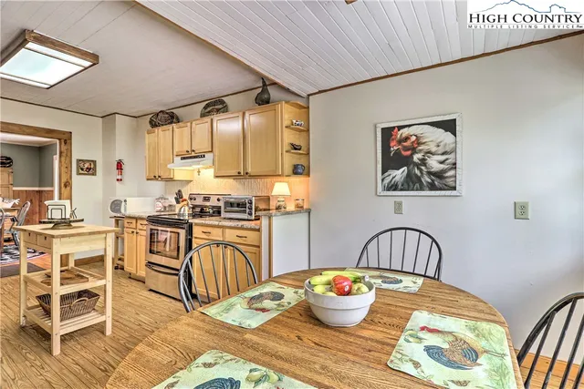 a kitchen with a table chairs stove and wooden floor