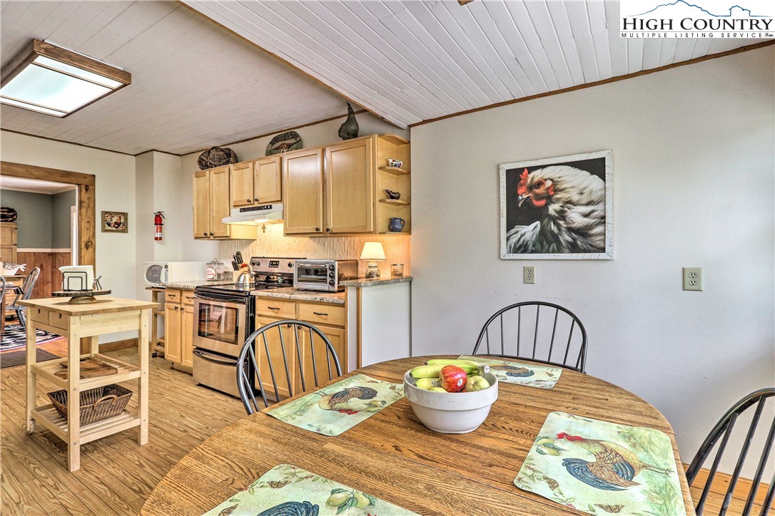 2280 Garvey Bridge Road Crumpler, NC 28617 - Photo 12 of 40 a kitchen with a table chairs stove and wooden floor