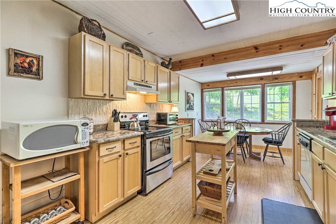 2280 Garvey Bridge Road Crumpler, NC 28617 - Photo 16 of 40 a kitchen with a table chairs stove and cabinets