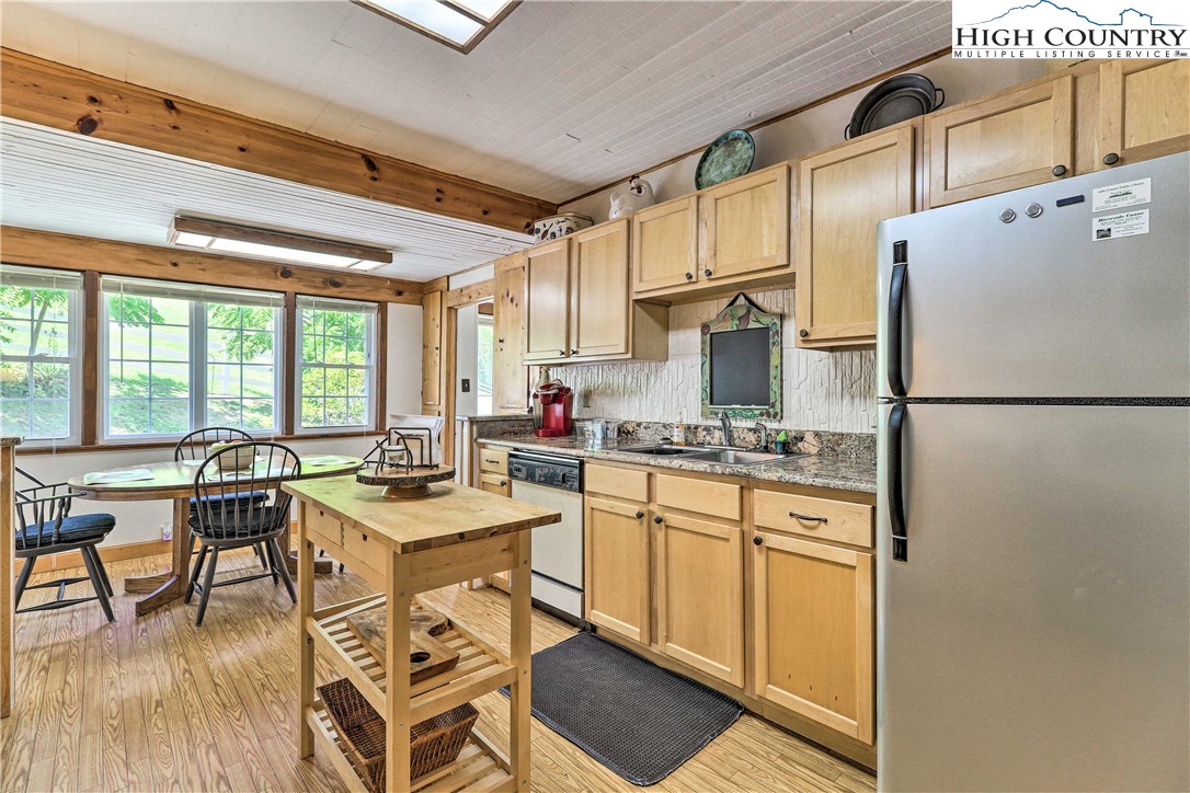 2280 Garvey Bridge Road Crumpler, NC 28617 - Photo 18 of 40 a kitchen with a table chairs refrigerator and cabinets