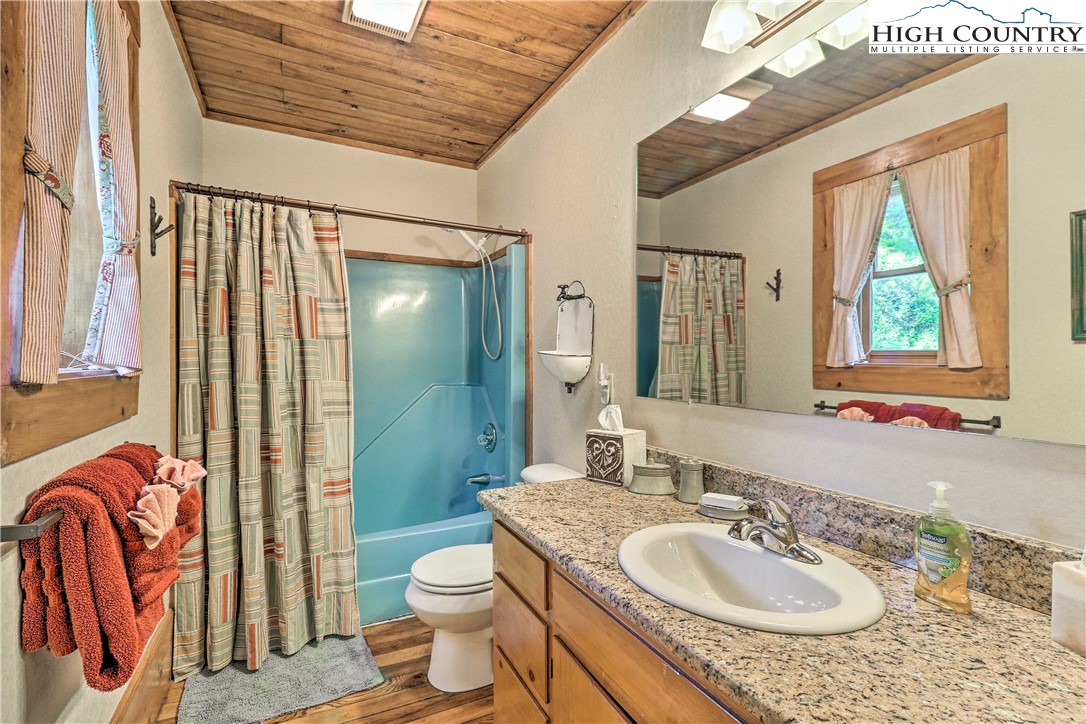 2280 Garvey Bridge Road Crumpler, NC 28617 - Photo 9 of 40 a bathroom with a granite countertop sink and a mirror