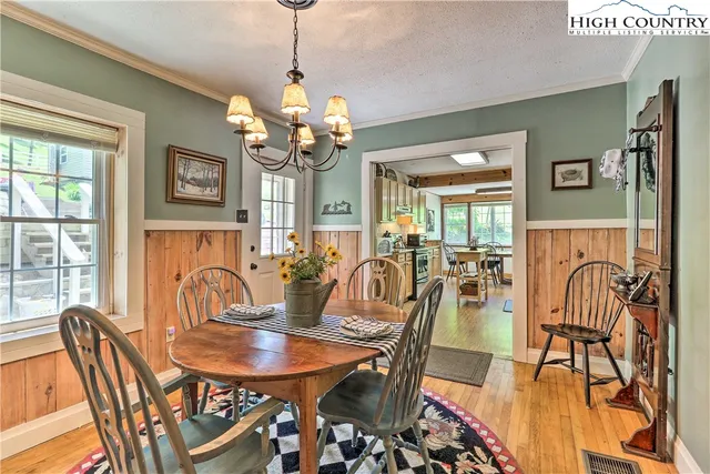 a view of a dining room with furniture a chandelier and wooden floor