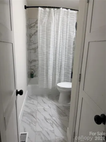 a bathroom with a toilet and a shower