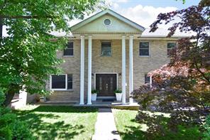 a front view of a house with a garden and plants