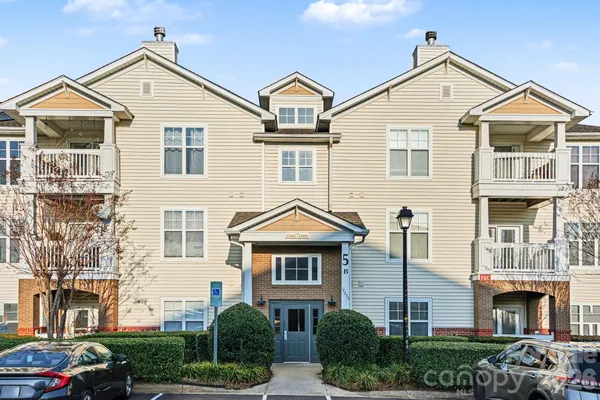 a view of a brick house with many windows and a yard