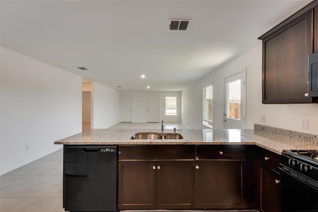 6112 Determine Lane Forney, TX 75126 - Photo 17 of 17 Kitchen featuring dark brown cabinets, black appliances, light stone counters, recessed lighting, and open floor plan